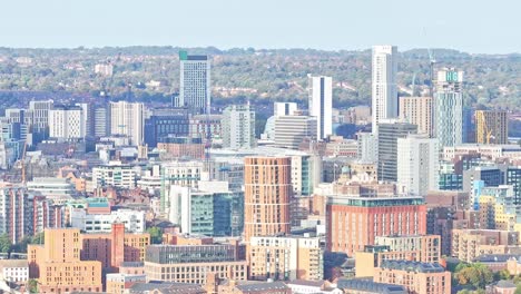 Descending-drone-shot-of-Leeds-City-with-skyline-and-towers-during-sunny-day,-United-Kingdom---wide-shot