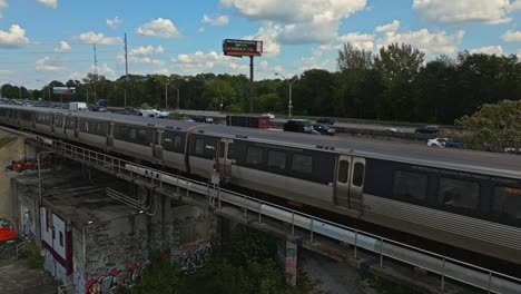 Passenger-train-drives-at-high-speed-parallel-to-expressway,-Downtown-Atlanta,-Georgia,-USA