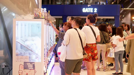 Shoppers-playing-some-fun-arcade-games-in-a-hall-inside-Terminal-21-Mall-in-Bangkok,-Thailand