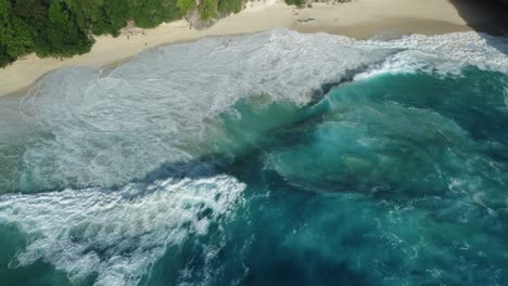 Atemberaubender-Sonnenuntergang-Am-Strand-Von-Kelingking:-4K-Drohnenvideo-Aus-Der-Luft,-Das-Gefährliche-Klippen,-Türkisfarbene-Wellen-Und-Einen-Einsamen-Strand-Auf-Bali,-Nusa-Penida,-Zeigt