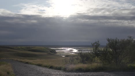 Paisaje-Islandés-Con-Humedales-Iluminados-Por-El-Sol-Y-Camino-De-Grava