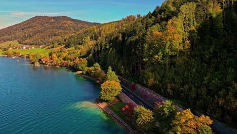 Aerial-view-of-a-coastal-road-on-the-shore-of-lake-Attersee,-fall-day-in-Austria