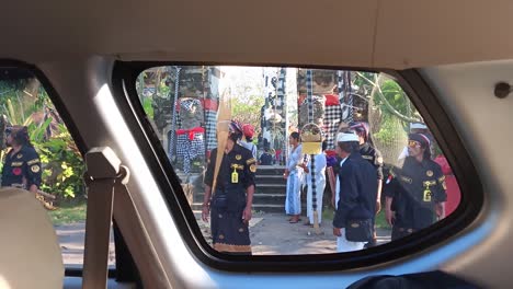 Pov-inside-a-car-people-walk-to-pray-in-Hindu-religious-traditions-in-Nusa-Penida,-Bali,-Indonesia