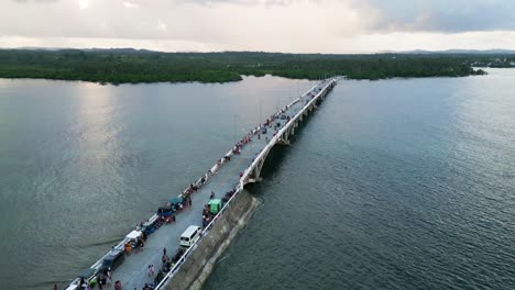 Aerial-shot-of-Siargao-Catangnan-bridge-with-people-and-traffic,-Philippines