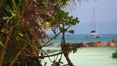 Palmeras,-Aguas-Azul-Turquesa-Y-Un-Catamarán-En-Las-Islas-Seychelles,-Océano-Índico.