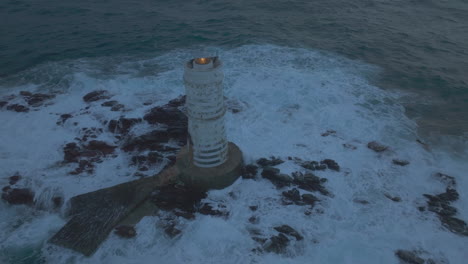 Under-the-Evening-Glow:-Mangiabarche-Lighthouse-in-All-Its-Splendor-with-Waves-Splashing-Around-in-Sardinia