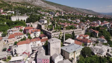 Aerial:-Historic-War-Damaged-Building-in-Mostar's-Landscape,-Bosnia