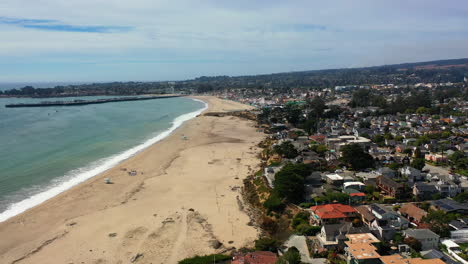 Aerial-view-overlooking-a-quiet-beach-in-cloudy-Santa-Cruz,-California,-USA