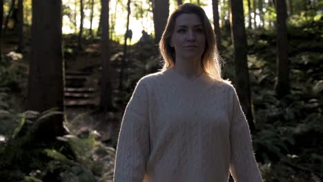 Joyful-Ukrainian-woman-wearing-sweater-walks-in-woods