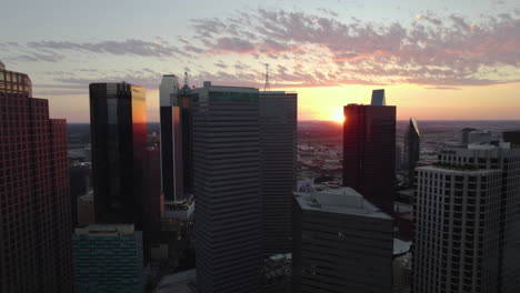 Aerial-pull-back-flying-in-front-of-high-rise-of-Dallas,-moody-evening-in-TX,-USA