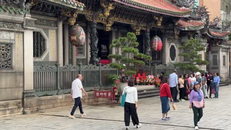 Tomas-Inclinadas-Hacia-Abajo-De-Los-Detalles-Arquitectónicos-Y-Las-Personas-Que-Ofrecen-Oraciones-Del-Famoso-Templo-Patrimonial-Bangka-Longshan-En-El-Distrito-De-Wanhua,-Taipei,-Taiwán