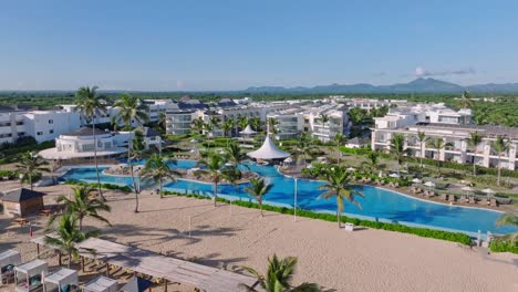 Tropical-Beachfront-Hotels-With-Swimming-Pool-On-A-Sunny-Summer-Day-In-Punta-Cana,-Dominican-Republic