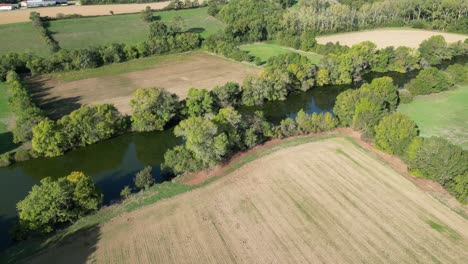 Luftaufnahme-Eines-Flusses-In-Frankreich-Mit-Hecken-Und-Feldern