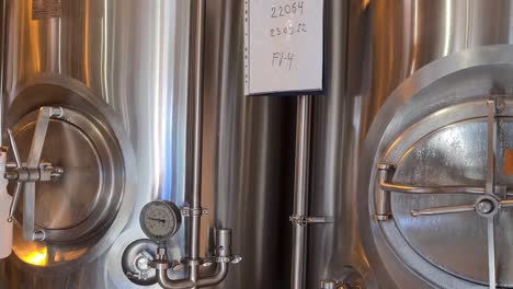 Small-beer-brewery-where-they-make-craft-beer,-close-up-of-beer-fermenting-tanks