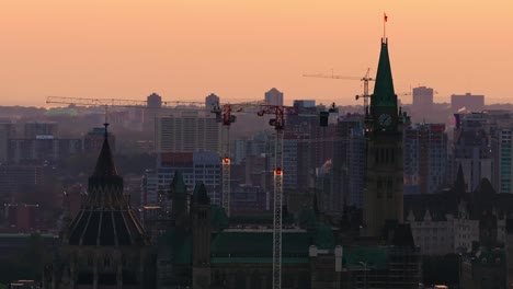 Telephoto-drone-shot-of-the-Canadian-parliament-and-peace-tower-with-many-cranes-and-buildings-under-construction-in-the-growing-city