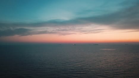 Drone-view-flying-over-the-Ligurian-Sea-off-the-coast-of-Cinque-Terre-Riveria,-Italy-at-twilight-in-4K