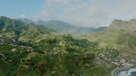 Aerial-drone-shot-of-the-Rainbow-in-the-high-mountains-with-green-forest