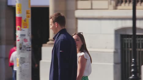 Close-up-of-tourist-couple-walking-on-sunny-street-during-city-trip