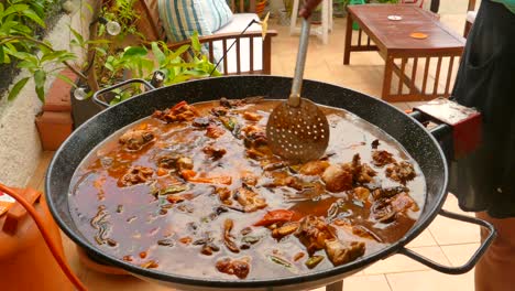 Close-up-shot-of-traditional-making-of-Paella-been-cooked-on-a-gas-stove-in-Valencia,-Spain-at-daytime