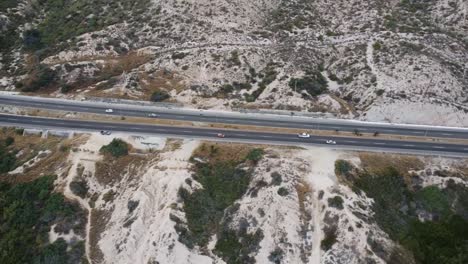 Aerial-view-from-a-busy-highway-in-the-middle-of-a-dry-landscape-with-little-vegetation-in-cabo-san-lucas-in-the-direction-of-san-jose-del-cabos-in-baja-california-sur-while-a-trip-through-mexico