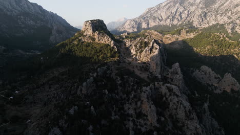 Mountain-range-of-stone-and-vegetation-partially-hidden-in-shadow
