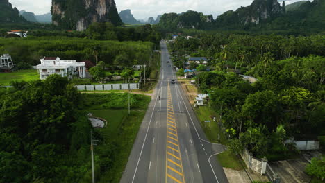 Road-with-traffic-and-endless-palm-trees-in-Krabi-province-with-beautiful-limestone-cliffs-near-AO-nang