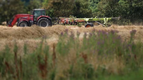 A-tractor-aerating-cut-grass-on-a-farm-field-in-rural-Denmark