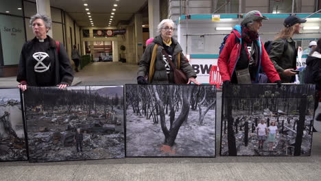 Drei-Extinction-Rebellion-Aktivisten-Stehen-Mit-Fotoplakaten,-Die-Klimakatastrophen-Zeigen,-Vor-Dem-Intercontinental-Hotel,-In-Dem-Das-Energy-Intelligence-Forum-Stattfindet