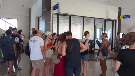 Tourists-stand-waiting-for-the-ship-to-arrive-which-will-take-them-on-a-trip-to-Nusa-Penida-Island,-Bali,-Indonesia