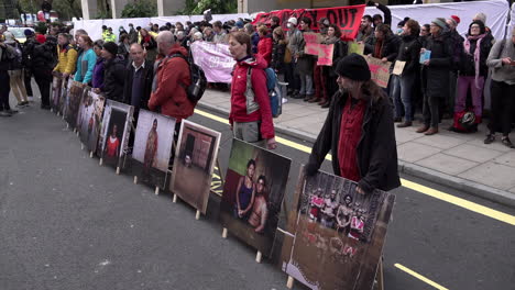 Aktivisten-Der-Extinction-Rebellion-Stellen-Sich-Mit-Fotoplakaten,-Die-Katastrophen-Des-Klimawandels-Zeigen,-Vor-Dem-Intercontinental-Hotel-In-Mayfair-Auf,-Wo-Das-Energy-Intelligence-Forum-Stattfindet