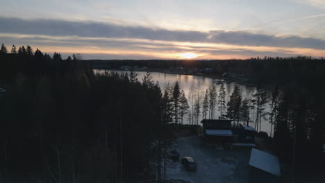 New-modern-lake-side-cabin-during-sunrise,-aerial-view