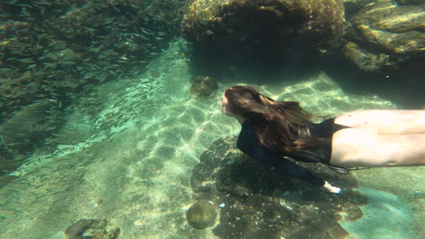 Female-freediver-snorkeling-in-Koh-tao,-underwater-view-with-fishes