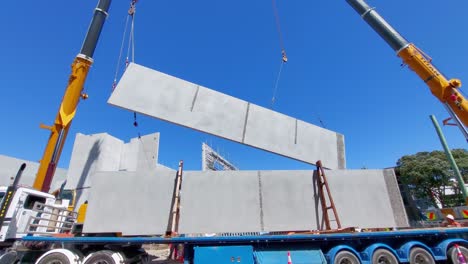 A-large-concrete-slab-being-rotated-in-the-air-by-two-cranes