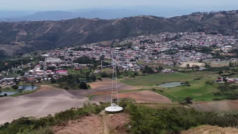 Visual-Aérea-Con-Drone-De-Una-Cruz-En-Una-Montaña-Y-Al-Fondo-El-Pueblo-De-Sarane,-Ubicado-En-El-Estado-De-Lara,-Venezuela