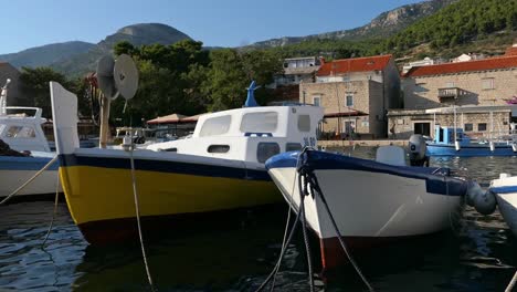 Traditional-fishing-boats-docked-in-harbor-in-seaside-village,-Bol,-Croatia