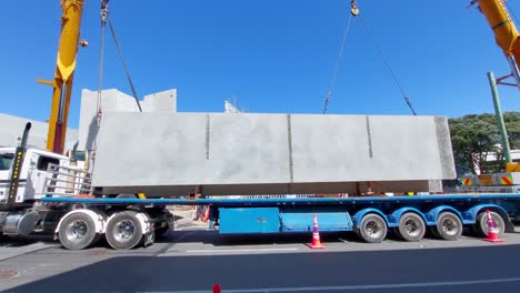 Eine-Große-Betonplatte-Wird-Von-Zwei-Kränen-Von-Einem-LKW-Gehoben