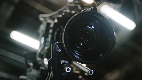 Low-angle-shot-of-a-professional-cinema-camera-and-long-telephoto-zoom-lens,-focus-motor-is-turning-the-gears-and-the-lens-element-is-moving-to-change-focus-distance