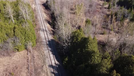Aerial-Shot-Of-A-Train-Line-Surrounded-By-Forest-Trees