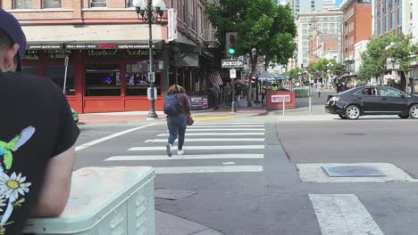 Street-with-pedestrians,-cars,-crossing-and-beautiful-historical-architecture-in-Downton-Gaslamp-district-in-San-Diego