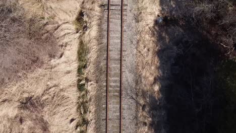 Aerial-View-Of-A-Train-Railway-Line-Surrounded-By-Grass-And-Trees