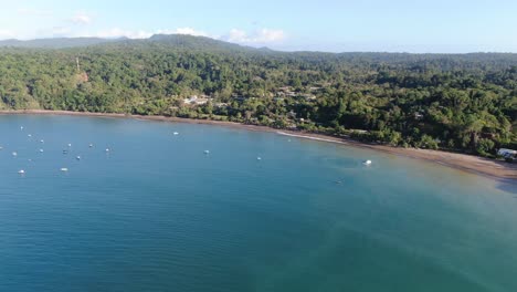 Costa-Rica-beach-drone-view-showing-sea,-shore-and-forest-on-a-sunny-day-over-the-pacific-ocean-in-the-caribbean