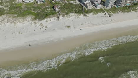 Drone-video-following-couple-walking-down-the-beach-revealing-the-coast-at-Cape-San-Blas,-Florida