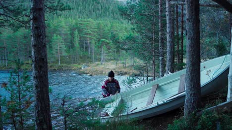 Man-Pulling-His-Boat-Onto-The-River-In-Hildremsvatnet,-Norway---wide