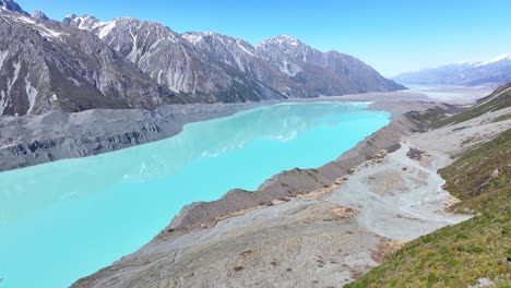 Turquoise-glacial-Tasman-Lake-and-mountain-range-reflection,-sunny-day