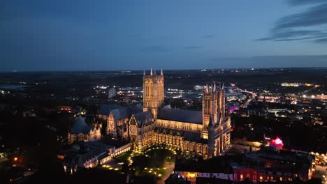 Aerial-drone-video-captures-the-iconic-Lincoln-Cathedral-in-Lincolnshire,-UK,-at-dusk,-highlighting-its-magnificent-illuminated-Gothic-architecture