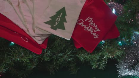 Zwei-Weihnachtsgeschenktüten-Logos-Aus-Stoff,-Girlande,-Lichter-–-Zeitlupe,-Breite-Bis-Mittlere-Aufnahme