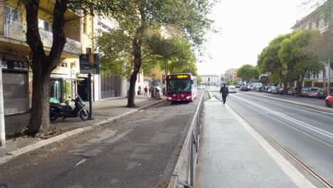 Red-ATAC-Bus-Driving-on-City-Street-in-Rome,-Italy