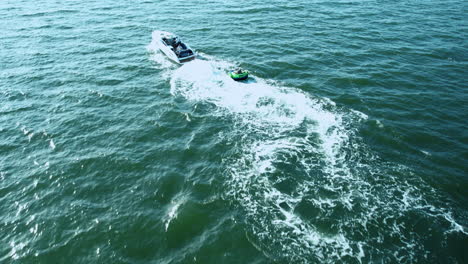 Boat-and-jet-ski-cruising-on-calm-waters,-creating-dynamic-wakes