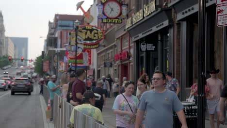 People-walking-along-Broadway-Street-in-Nashville,-Tennessee-in-slow-motion-during-the-day