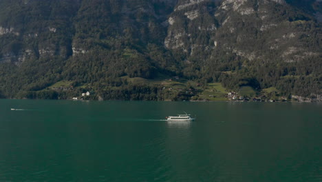 Flyby-shot-of-a-medium-size-tourist-boat-on-a-mountain-lake-at-summer